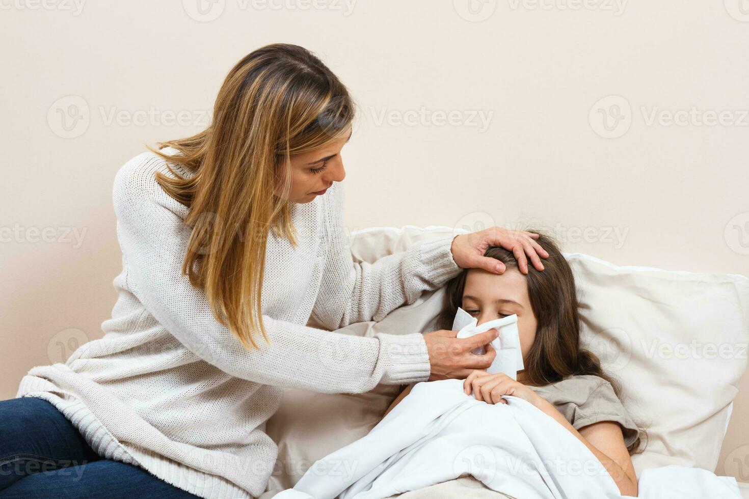 Little girl is having flu and mother is taking care of her photo
