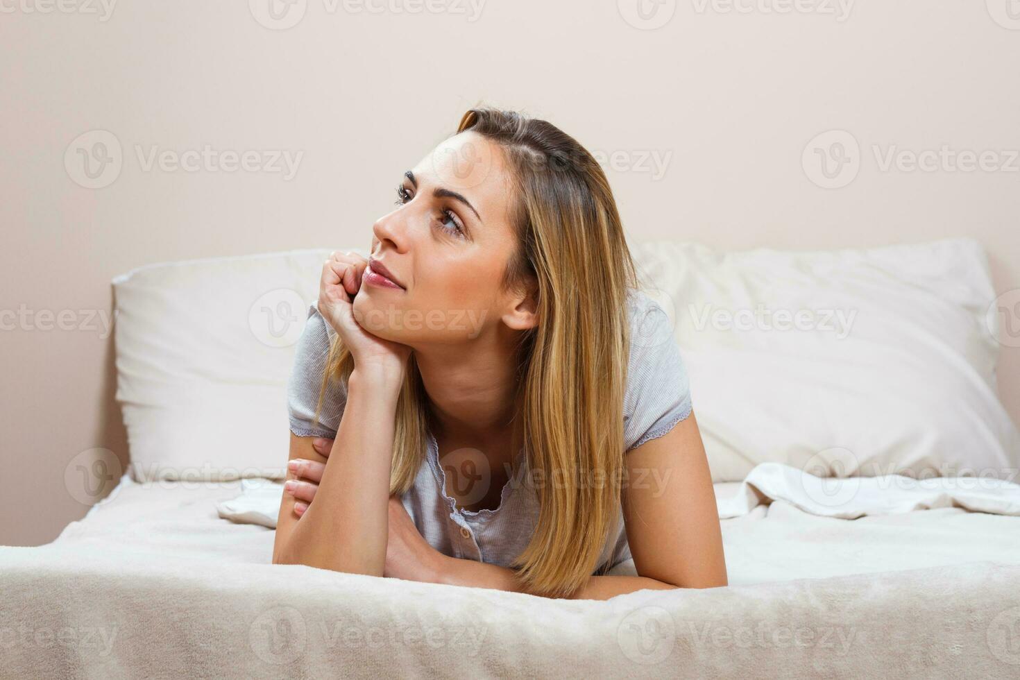 Happy woman lying on bed photo