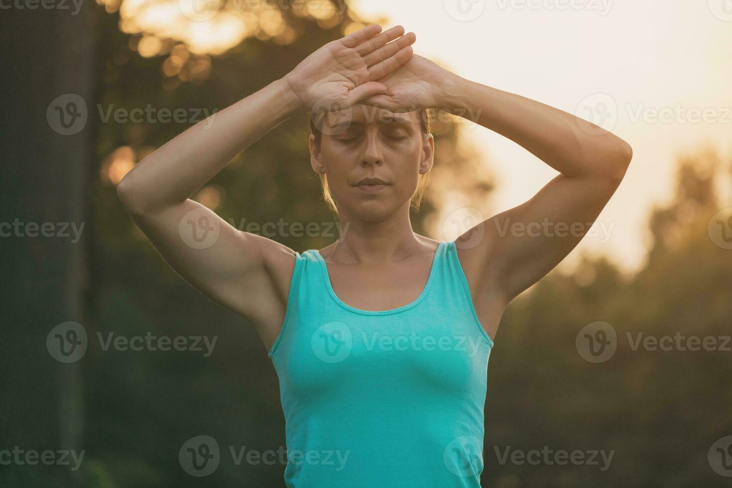 Beautiful woman enjoys exercising Tai Chi in the nature.Toned image. photo