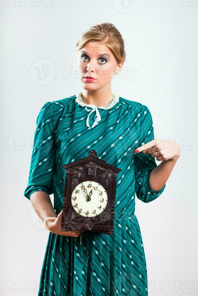 Retro woman pointing on old fashioned clock photo