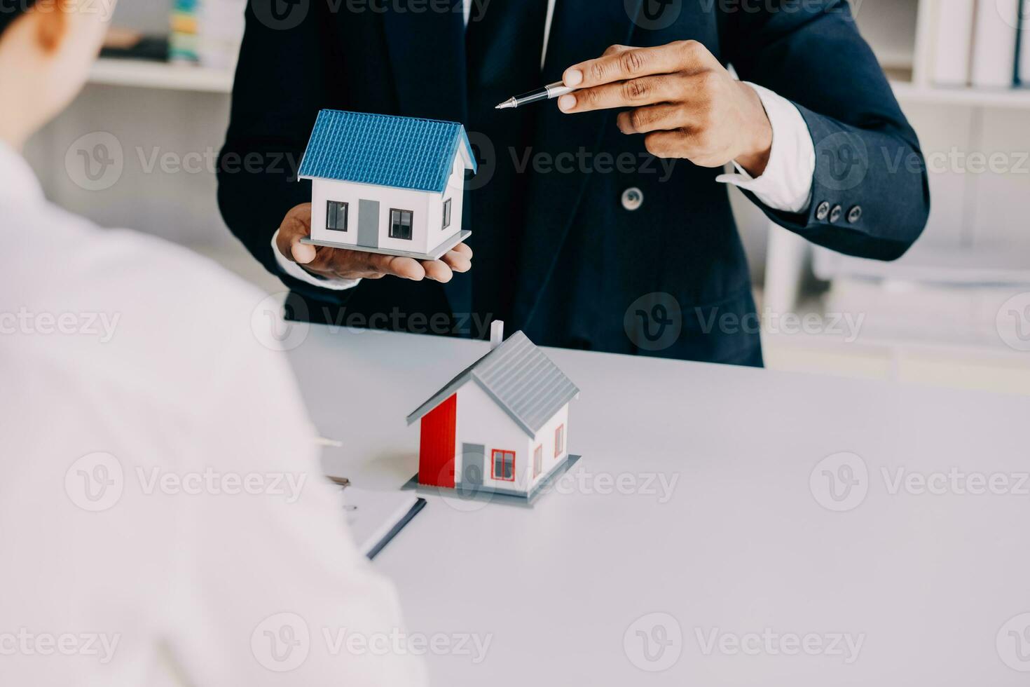 A couple is approaching a housing project to buy, and they are discussing details and advice with a salesperson in a housing project. Real estate trading ideas with couples. photo