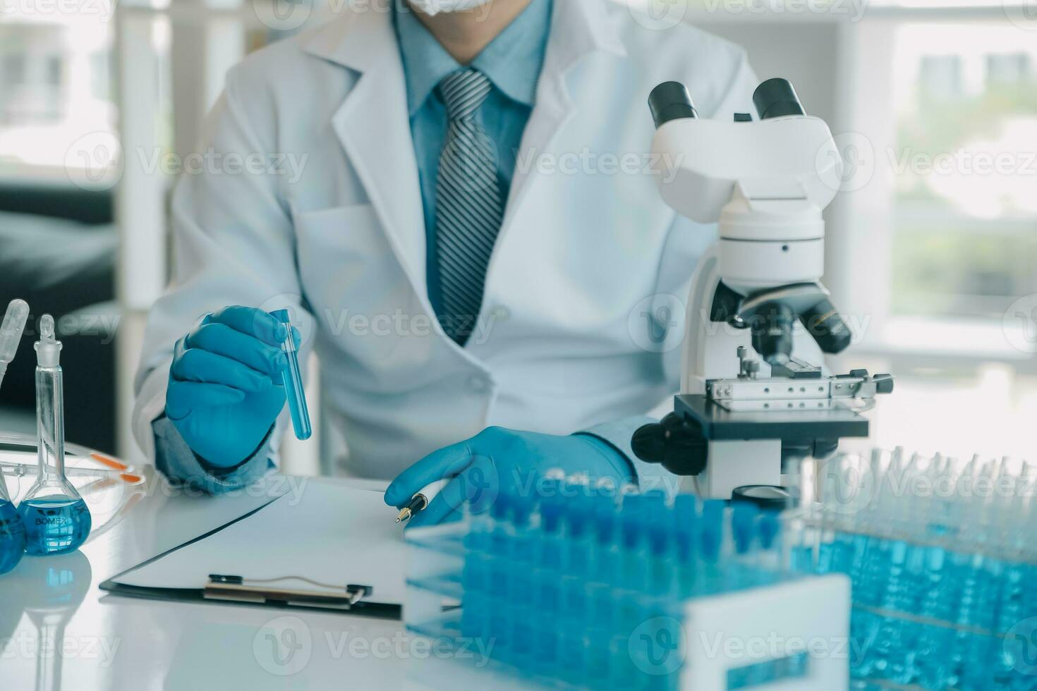 equipo científico de investigación bioquímica que trabaja con microscopio para el desarrollo de vacunas contra el coronavirus en laboratorios de investigación farmacéutica, enfoque selectivo foto