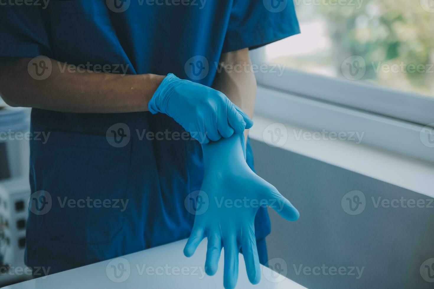 Doctor or nurse putting on blue nitrile surgical gloves, professional medical safety and hygiene for surgery and medical exam on white background. photo