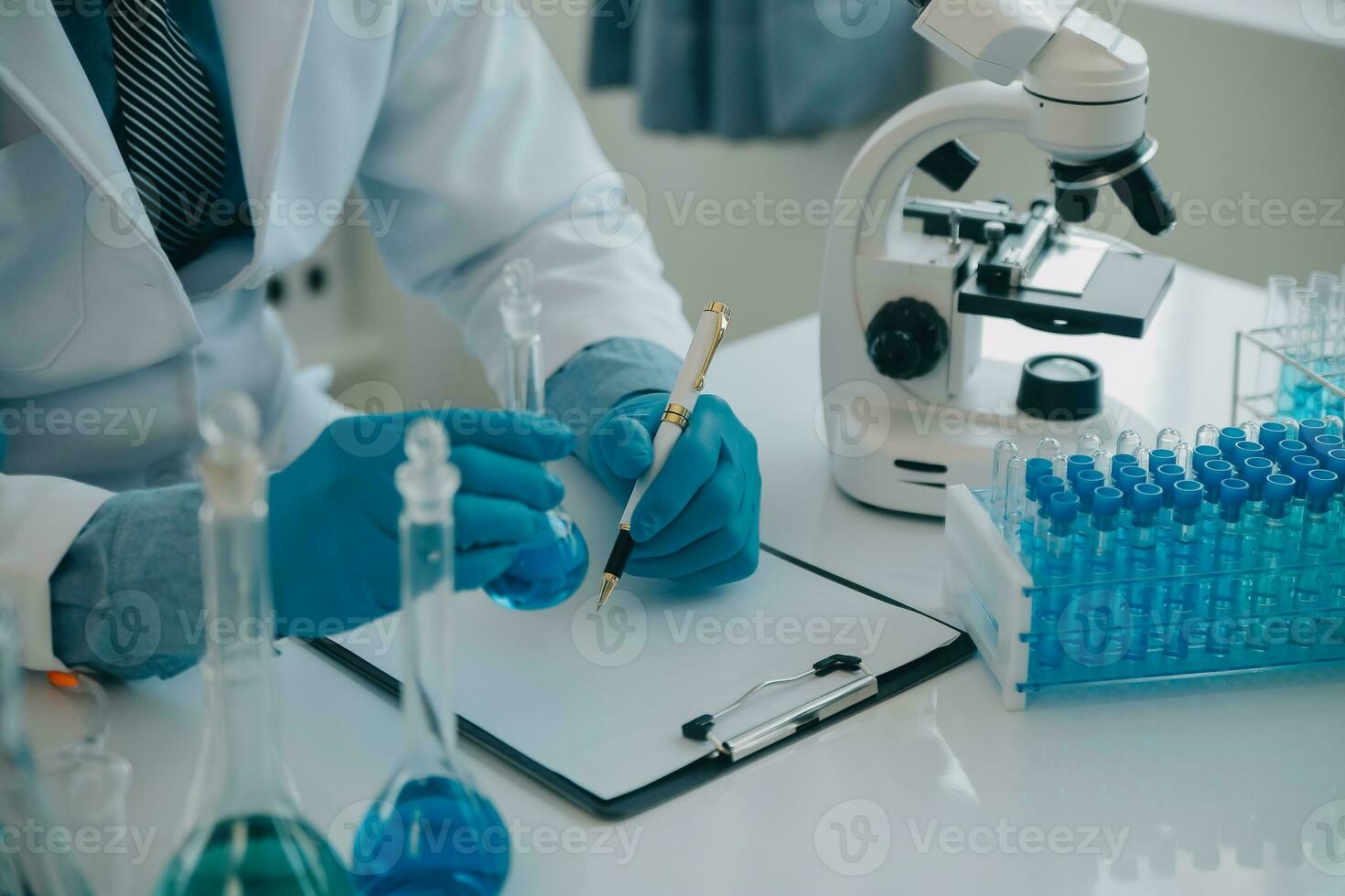 equipo científico de investigación bioquímica que trabaja con microscopio para el desarrollo de vacunas contra el coronavirus en laboratorios de investigación farmacéutica, enfoque selectivo foto