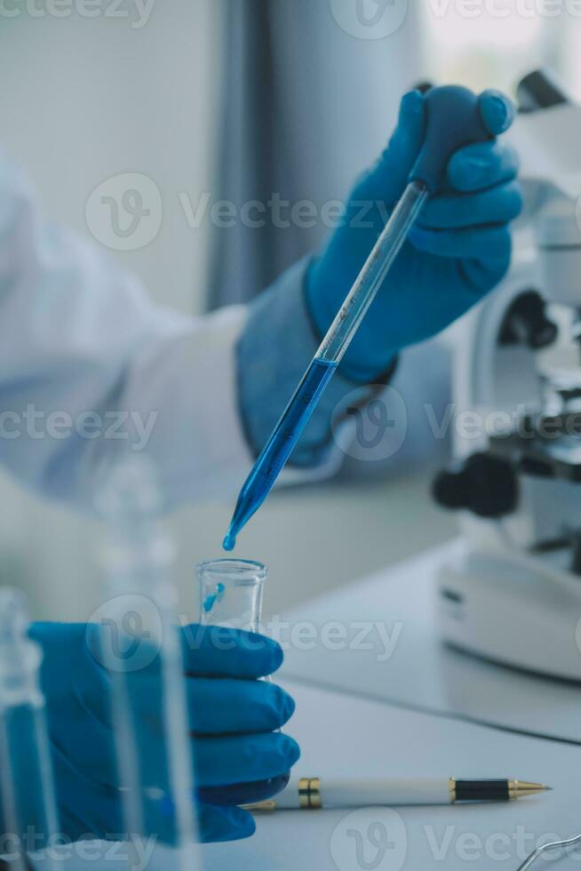 biochemical research scientist team working with microscope for coronavirus vaccine development in pharmaceutical research labolatory, selective focus photo