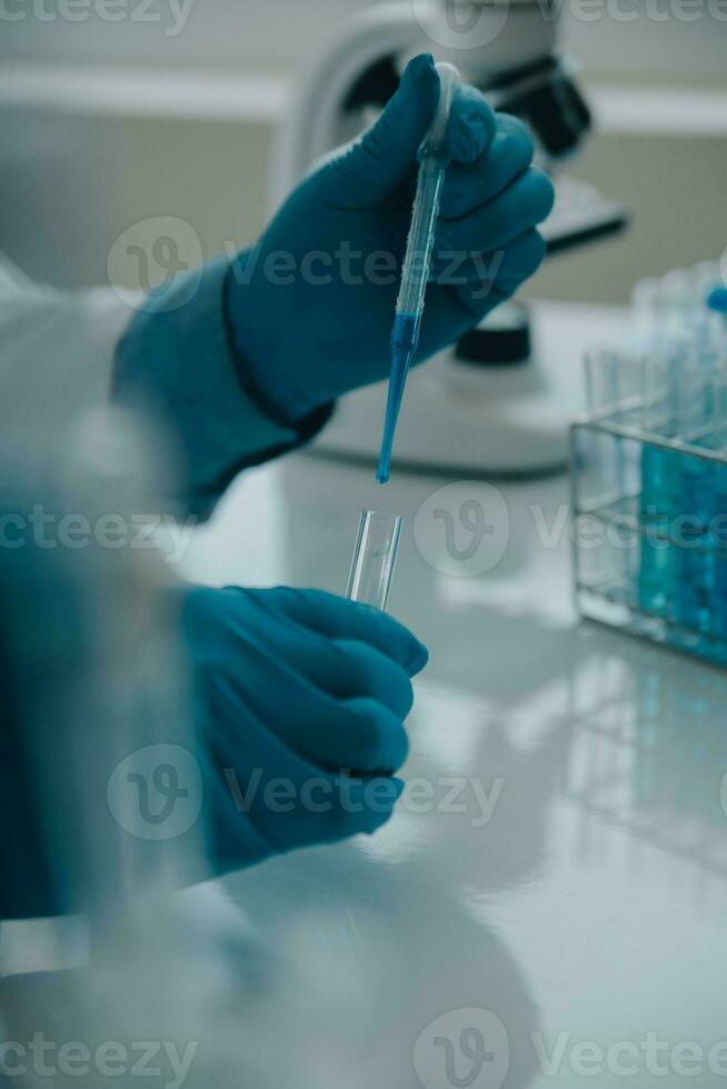 equipo científico de investigación bioquímica que trabaja con microscopio para el desarrollo de vacunas contra el coronavirus en laboratorios de investigación farmacéutica, enfoque selectivo foto