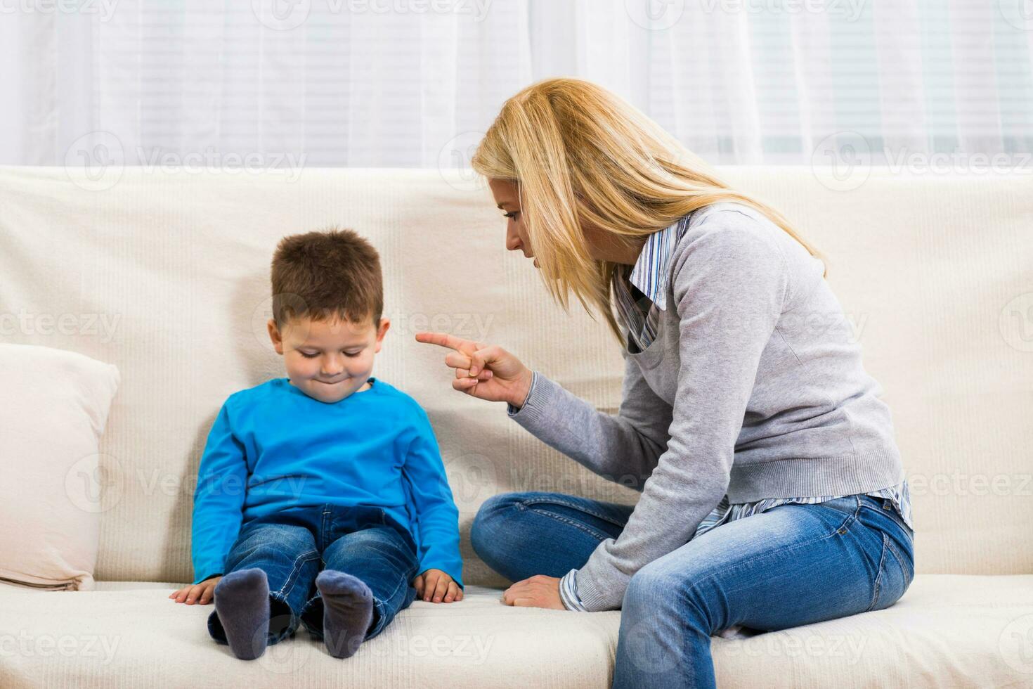 Angry mother is scolding at her son. photo