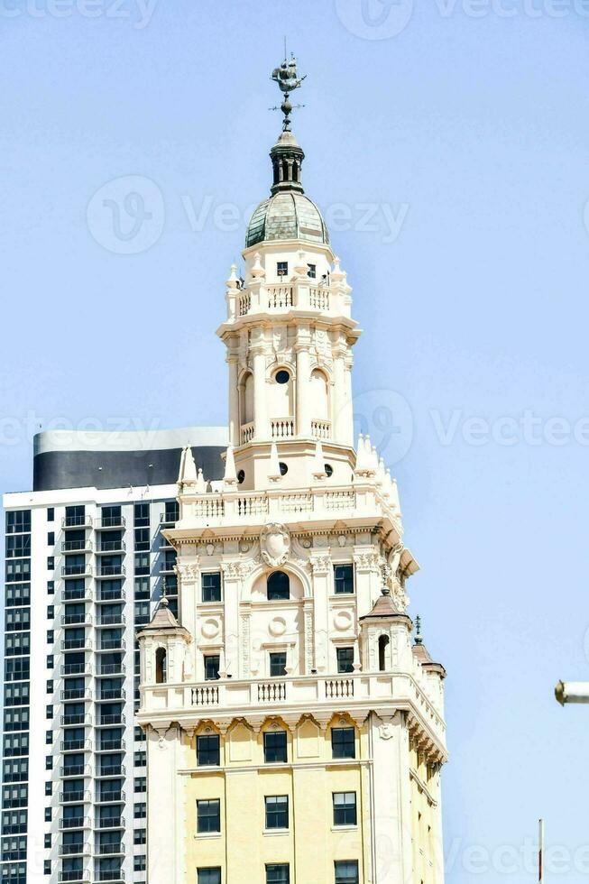 el edificio es alto y tiene un reloj en parte superior foto