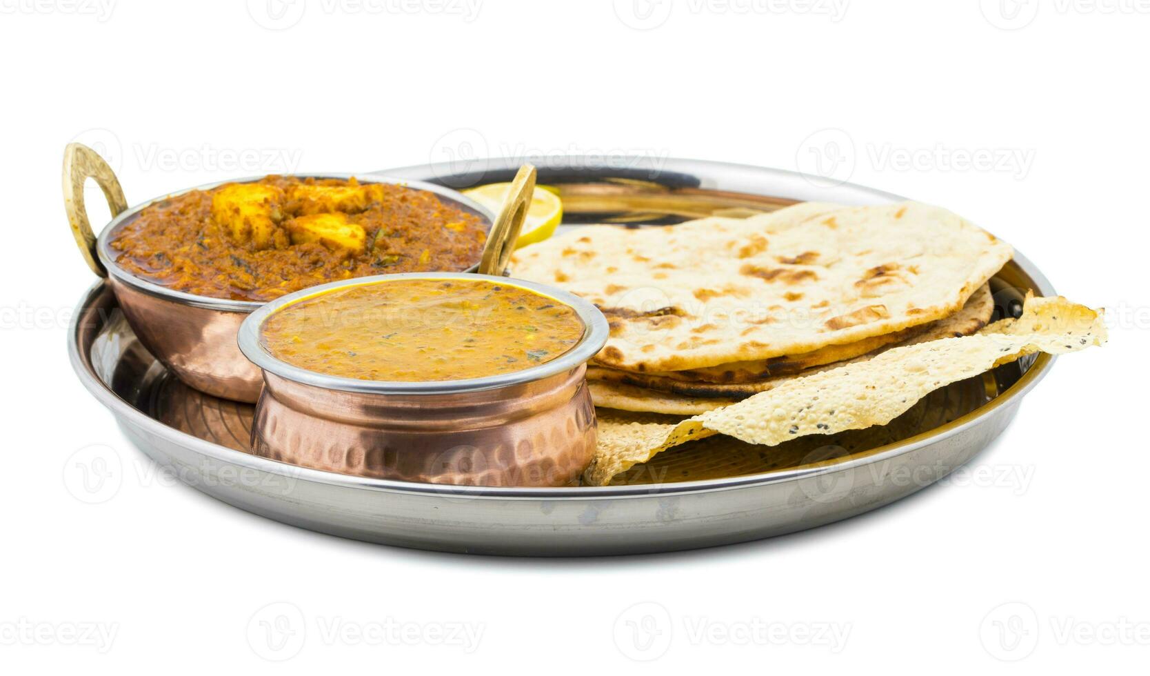 Indian Traditional Thali Food Dal Makhani Served with Chapati, Papad, Kadai Paneer or Lemon on White Background photo