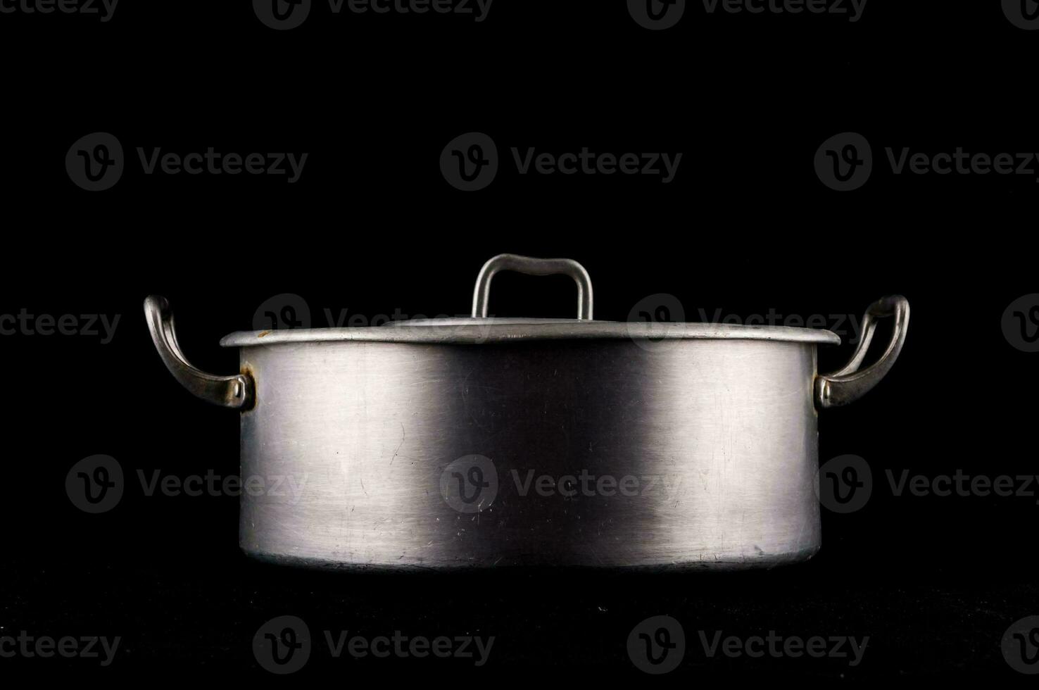 a metal pot on a black background photo