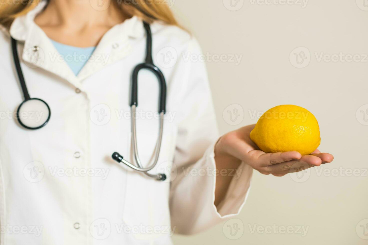 Image of female doctor holding lemon. photo