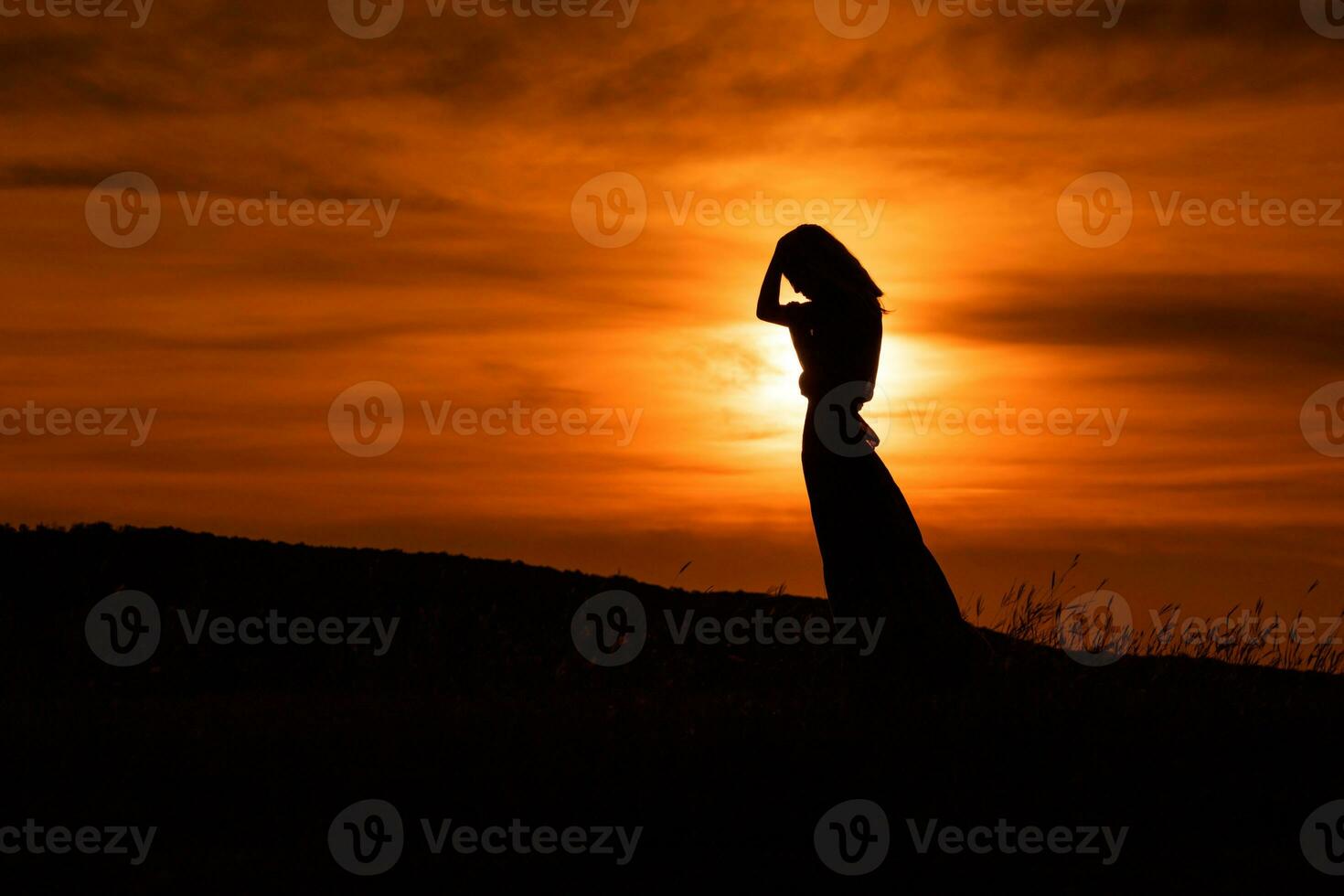 silueta de un triste mujer en pie a el puesta de sol. foto