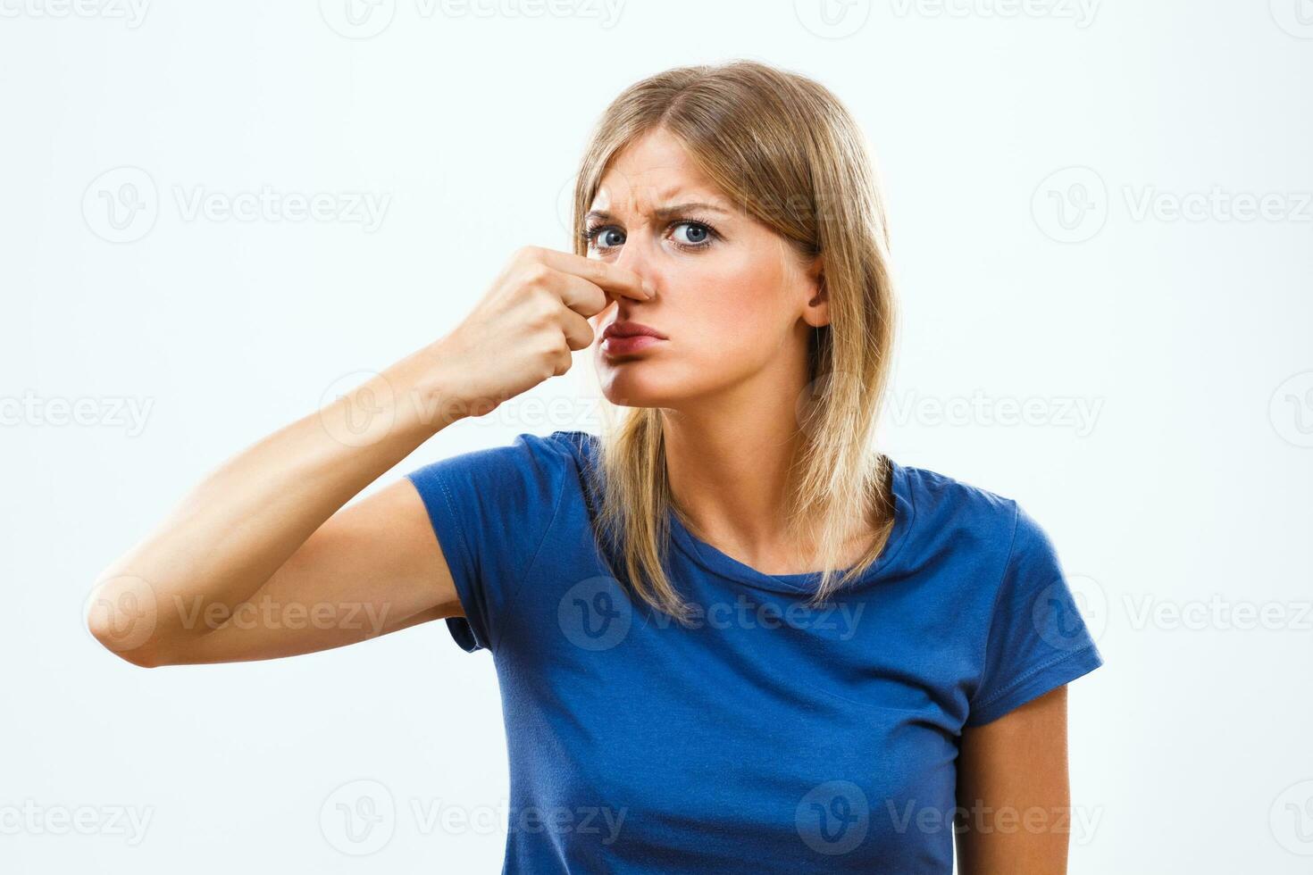 Woman is holding her nose because of unpleasant smell photo