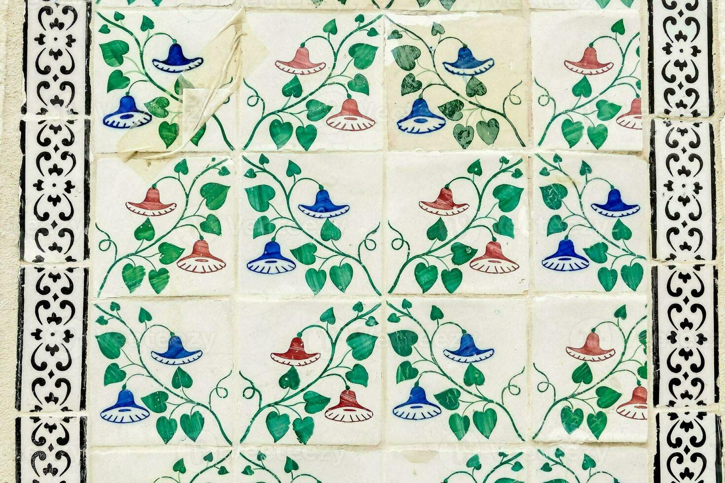 a tile with blue, green and red flowers on it photo