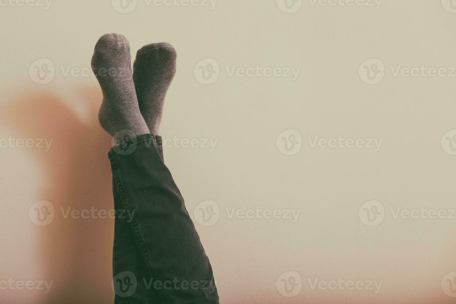 Woman resting with legs up in front of the wall.Toned photo. photo