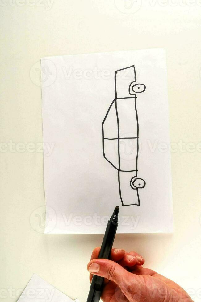 a hand drawing a car on paper photo