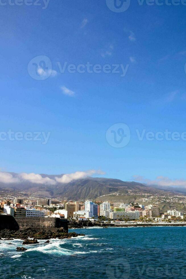 the coast of canary island with the mountains in the background photo