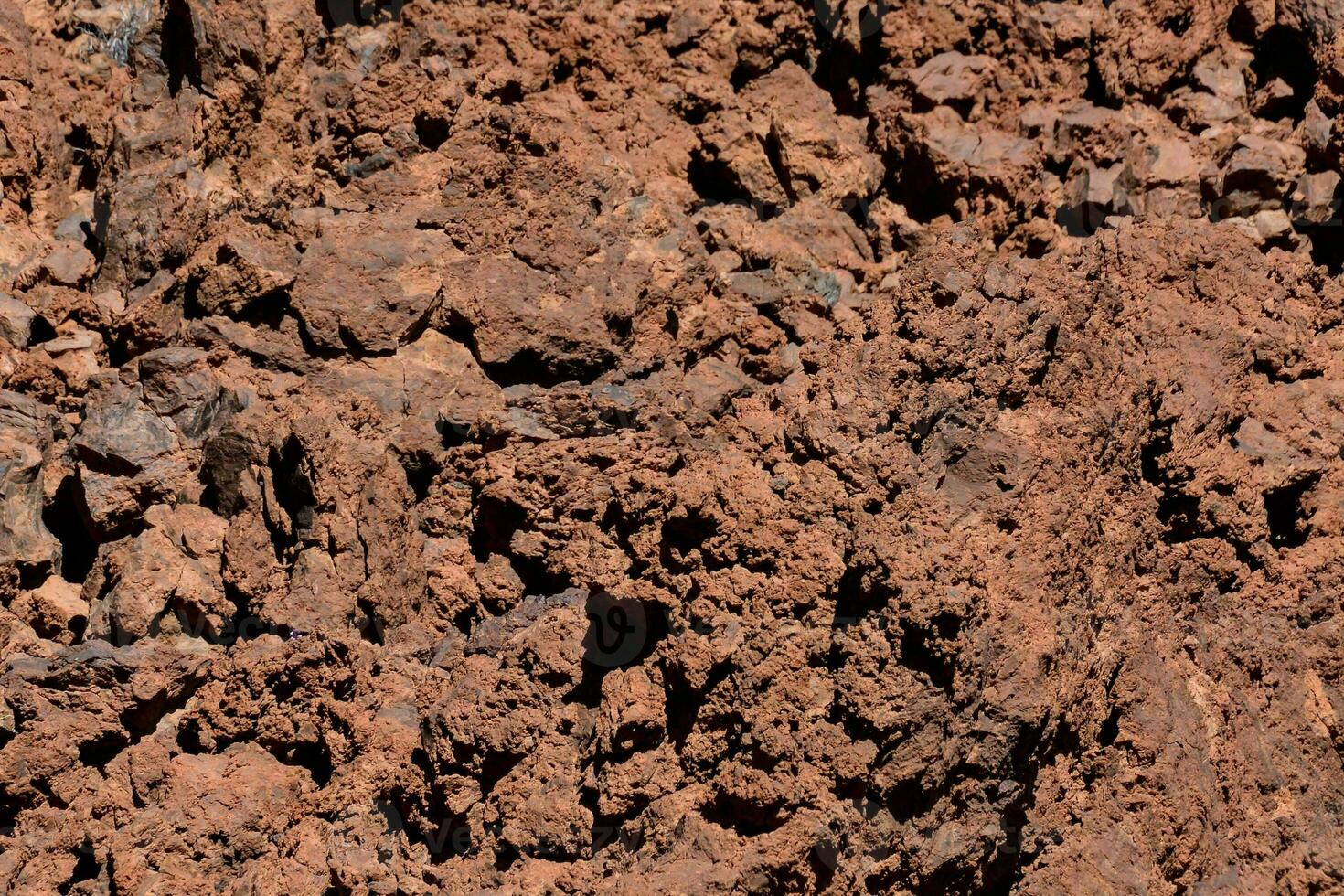 a close up of a red dirt surface photo