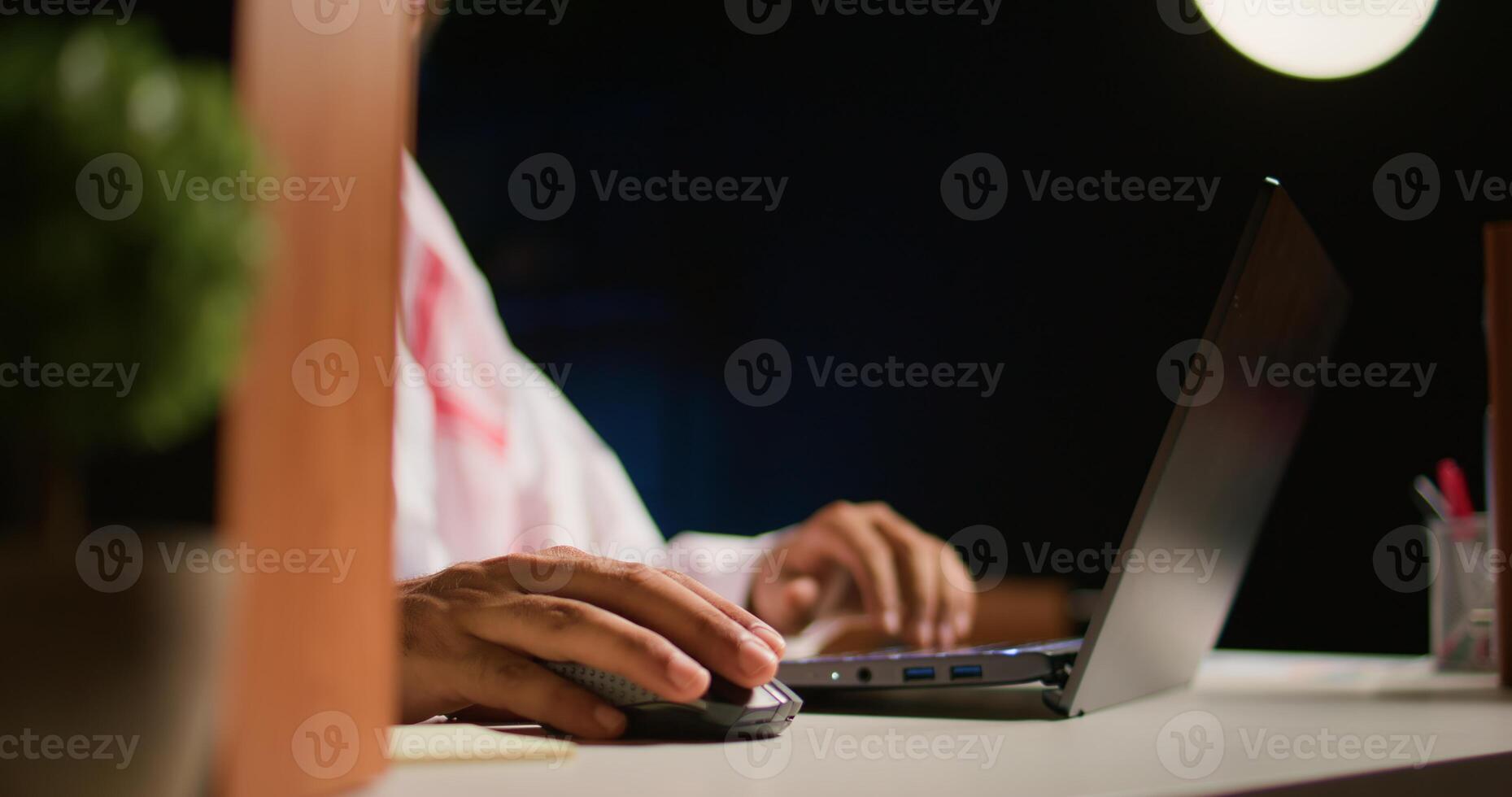 Close up shot of hardworking businessman using laptop keyboard and mouse at office desk to surf the internet. Company executive typing on digital device, finishing tedious paperwork photo