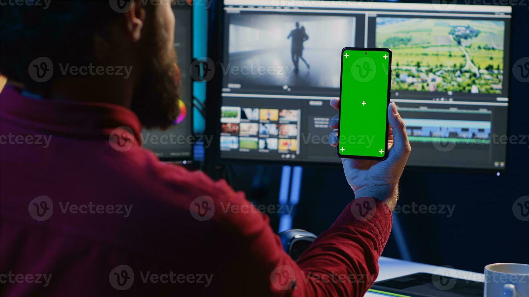 Video editor following tutorial on green screen smartphone, learning to select key frames to use in movie montage. Freelancing applying editing techniques seen online on chroma key phone photo