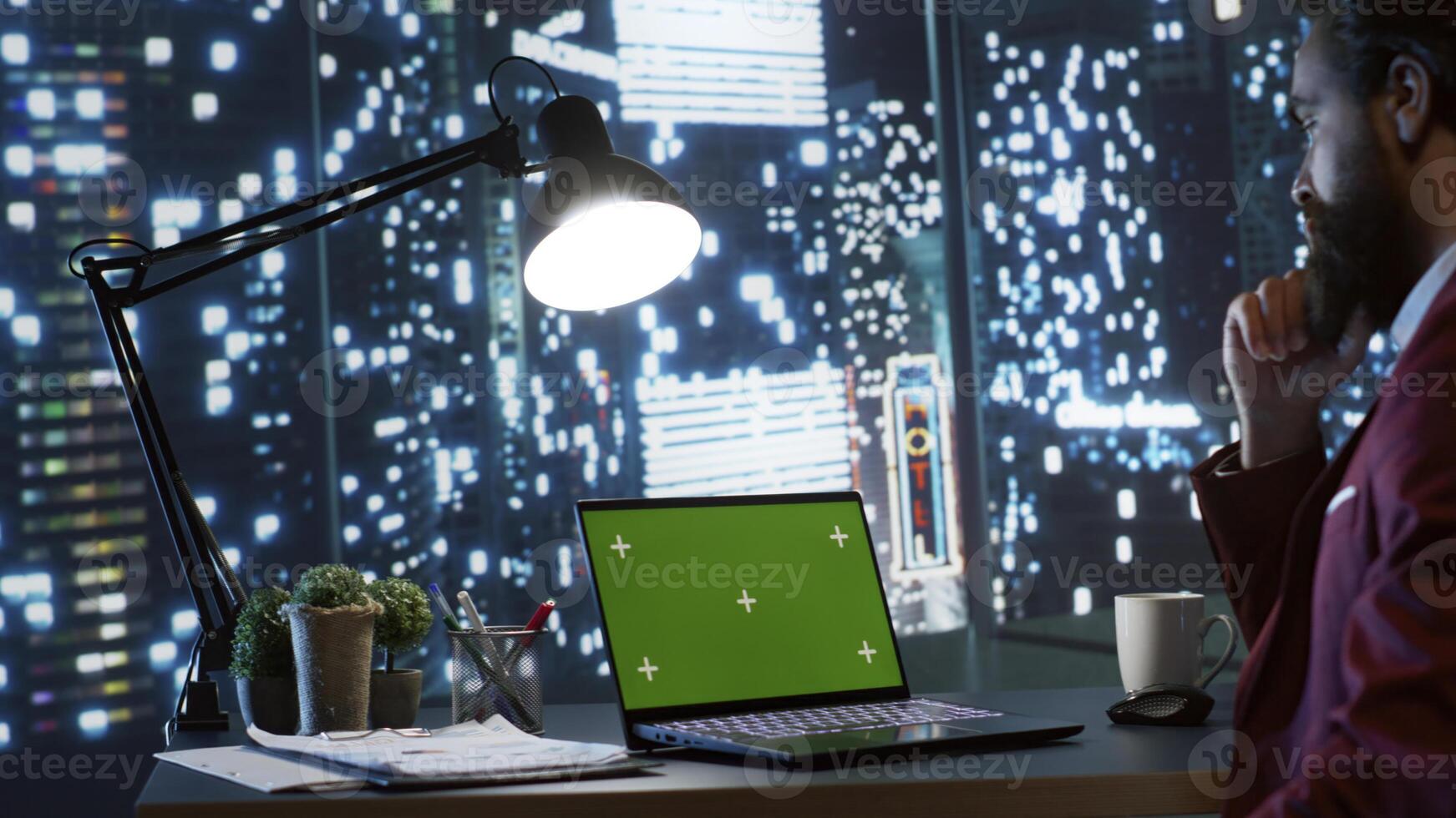 Rich businessman examine greenscreen on laptop, admiring city center view from his office desk. Professional executive director working after hours with blank copyspace mockup template. photo