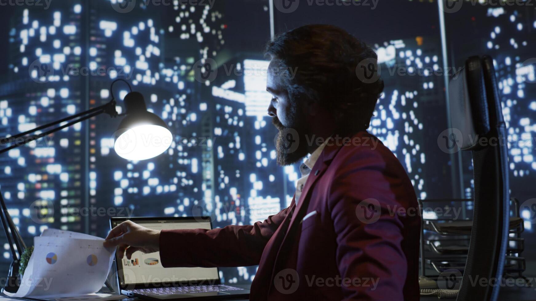 Executive director working at night in his skyscraper office building, examining global investment trends for new career opportunities. Influential businessman with billionaire vision checks reports. photo