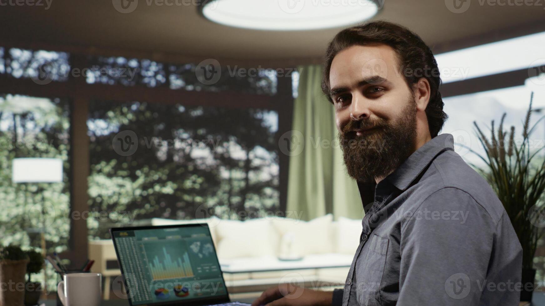 Business owner working on banking management at his modern mountain villa, looking at income trends. Self employed billionaire sitting at desk, hopping online to help his investment team. photo