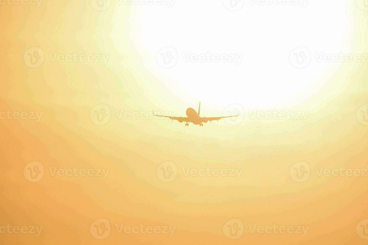 an airplane flying in the sky with the sun in the background photo