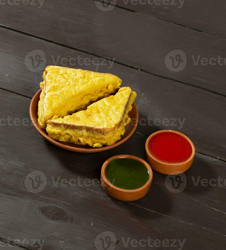 Indian Fried Snack Bread Pakora or Bread Bhaji Served with Tomato Ketchup, Green Chutney it is Made From Bread Slices photo