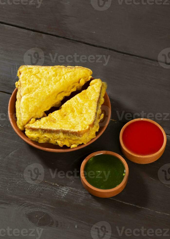 Indian Fried Snack Bread Pakora or Bread Bhaji Served with Tomato Ketchup, Green Chutney it is Made From Bread Slices photo
