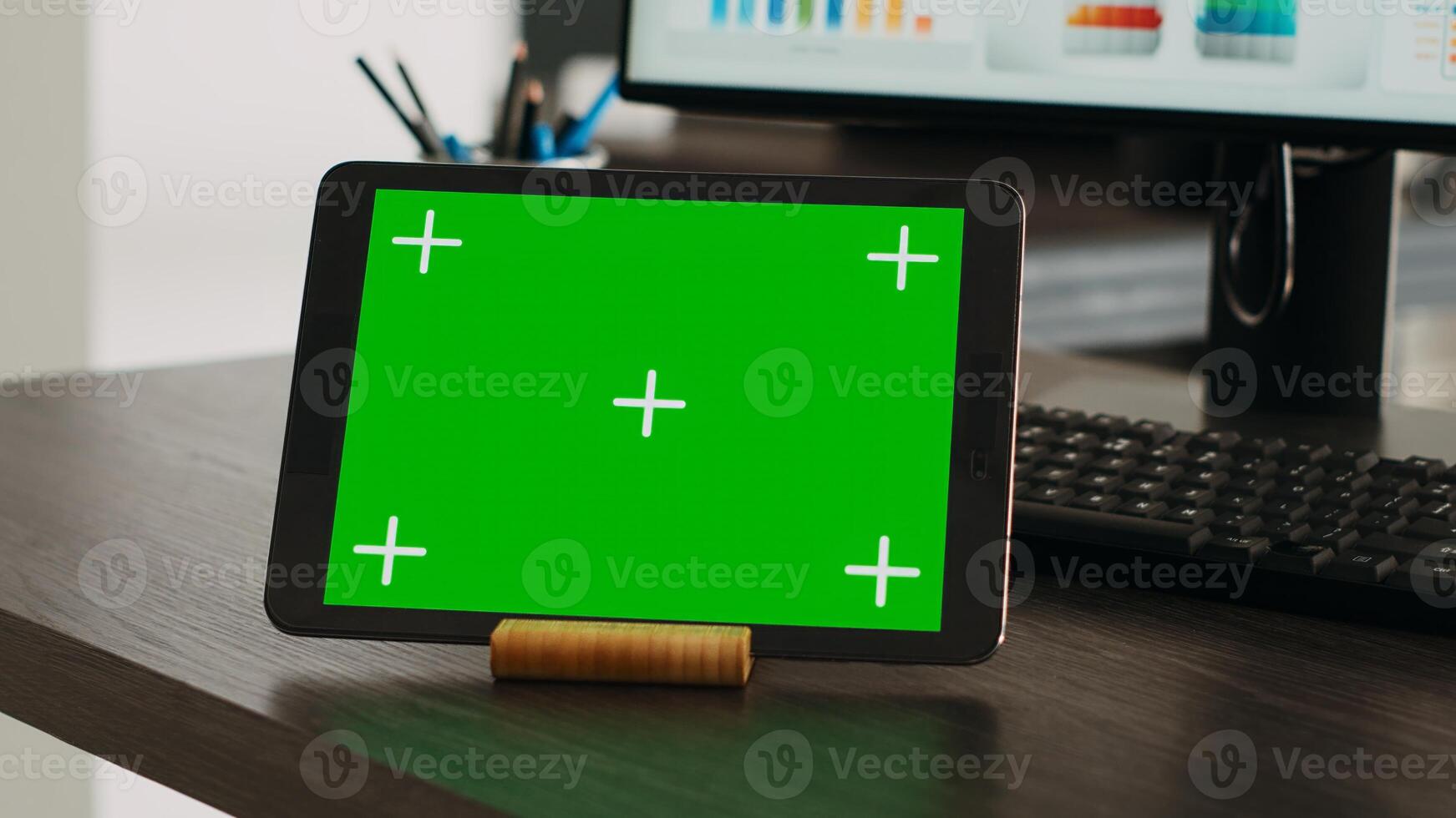 Greenscreen projection on interactive tablet with chromakey theme appears on company desk. Isolated mockup design displayed on advanced handheld gadget, blank copyspace layout. Close up. photo