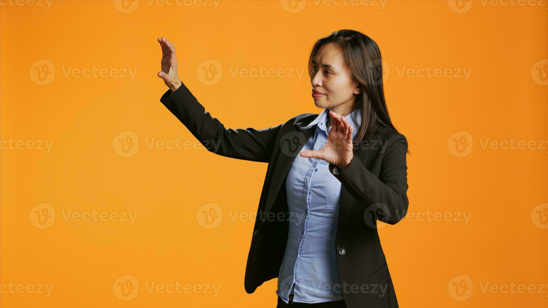 Office worker uses metaverse holographic image in studio, examining modern artificial intelligence reflection in front of camera. Businesswoman checks hologram icon projection. photo