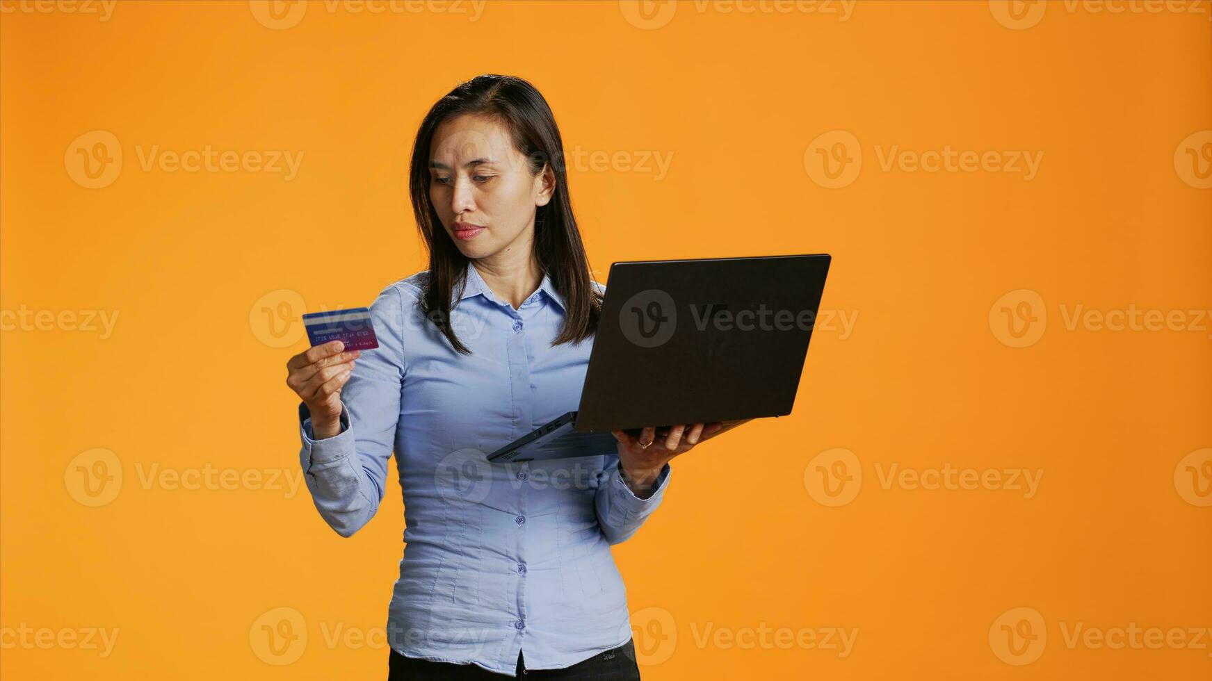 Trendy woman ordering products online on laptop, using credit card to make electronic payment remotely. Young adult putting banking credentials on website for shopping session. photo