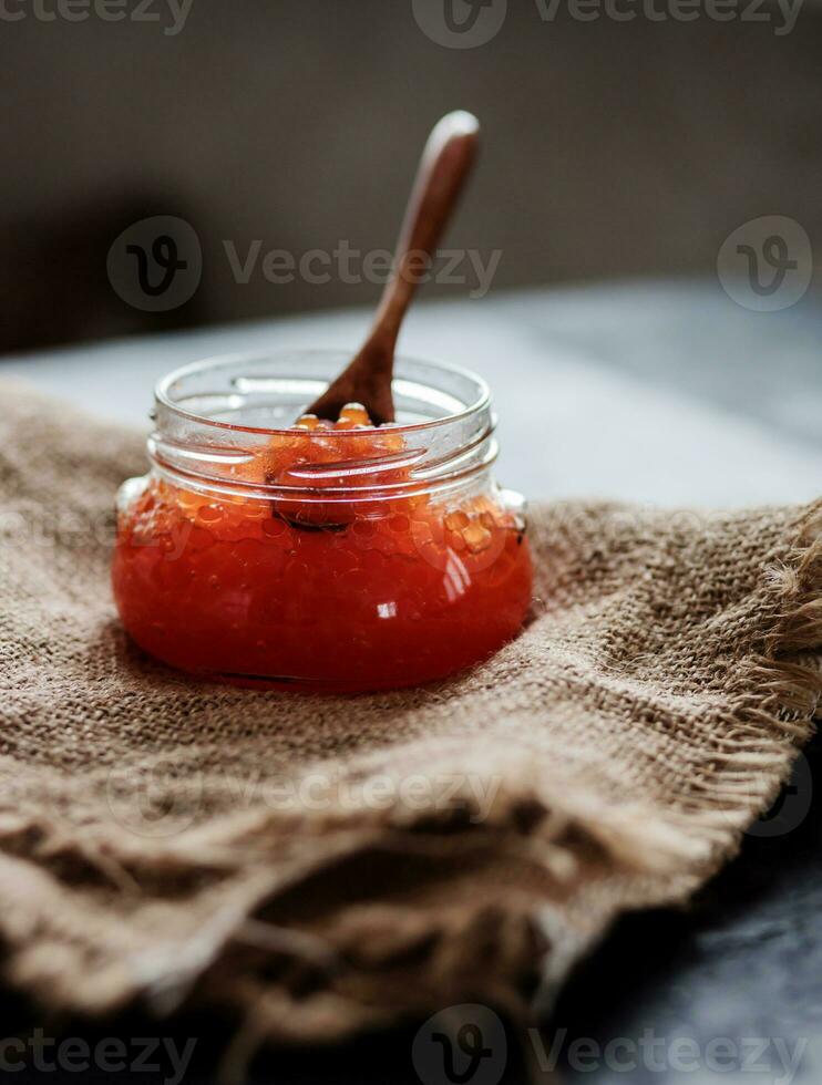 Glass jar with delicious red caviar photo