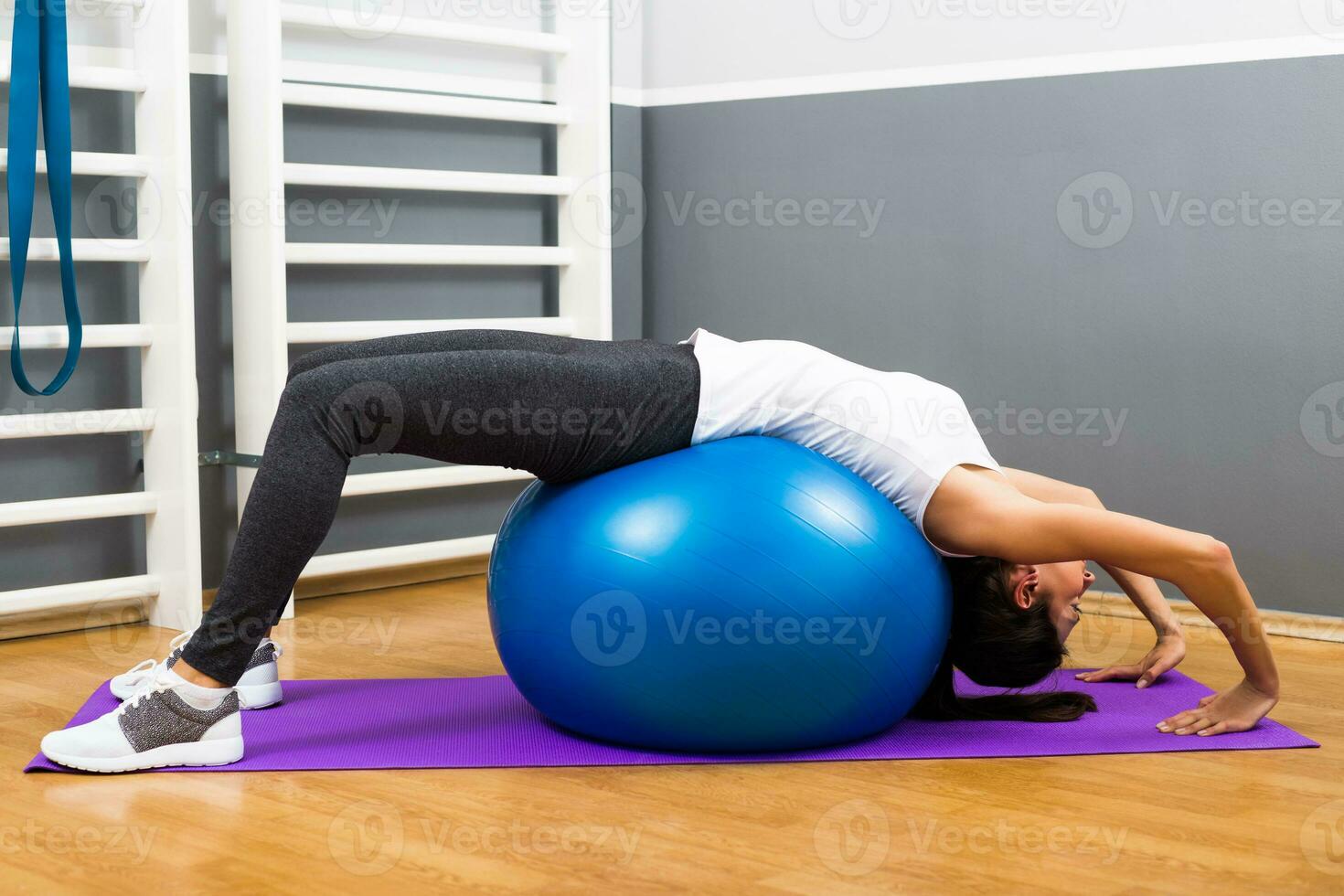 Beautiful young woman exercising with pilates ball. photo