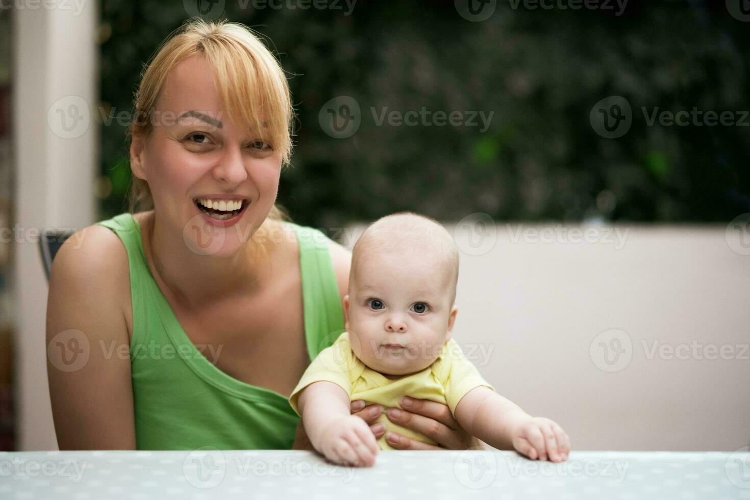 madre disfruta gasto hora con su pequeño alegre bebé chico. foto