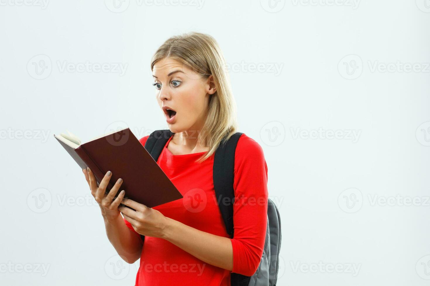 Surprised student reading book photo