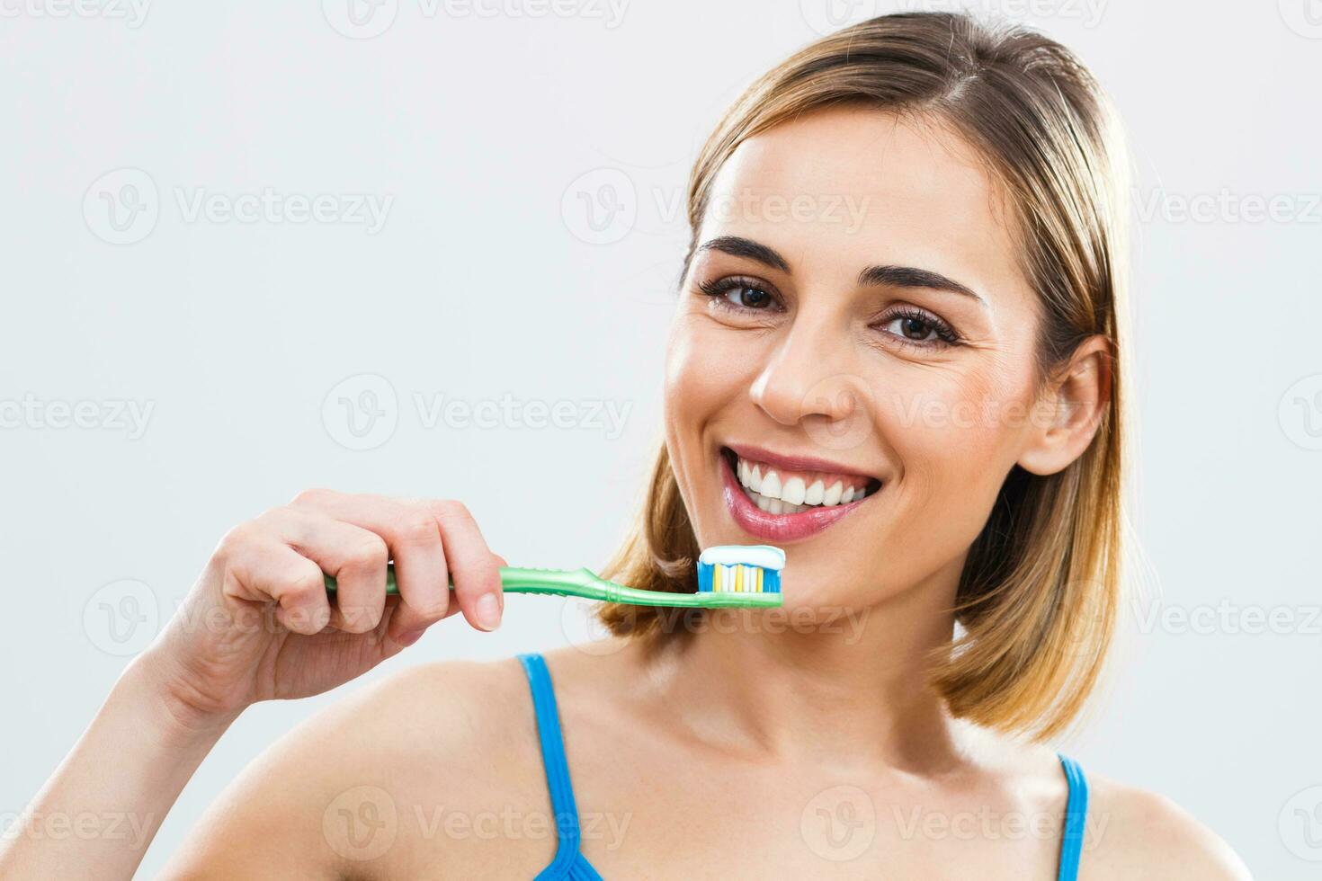 Woman is holding a toothbrush photo