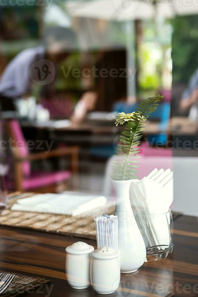 Hotel restaurant space with tables set for dinner at luxury resort, view through by window. photo