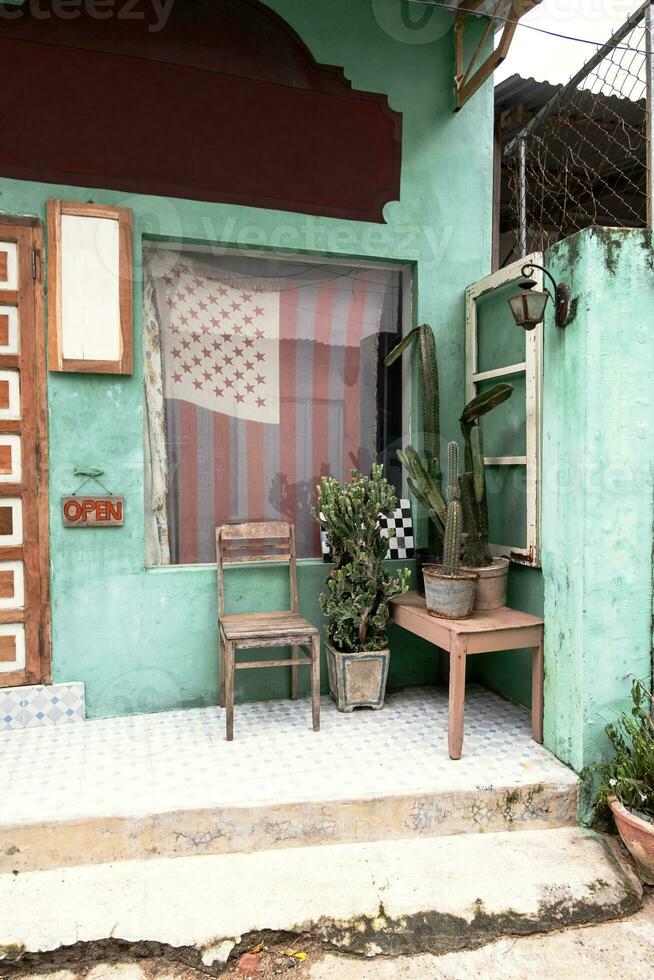 Old chair and cacti near front door of small vintage country store. photo