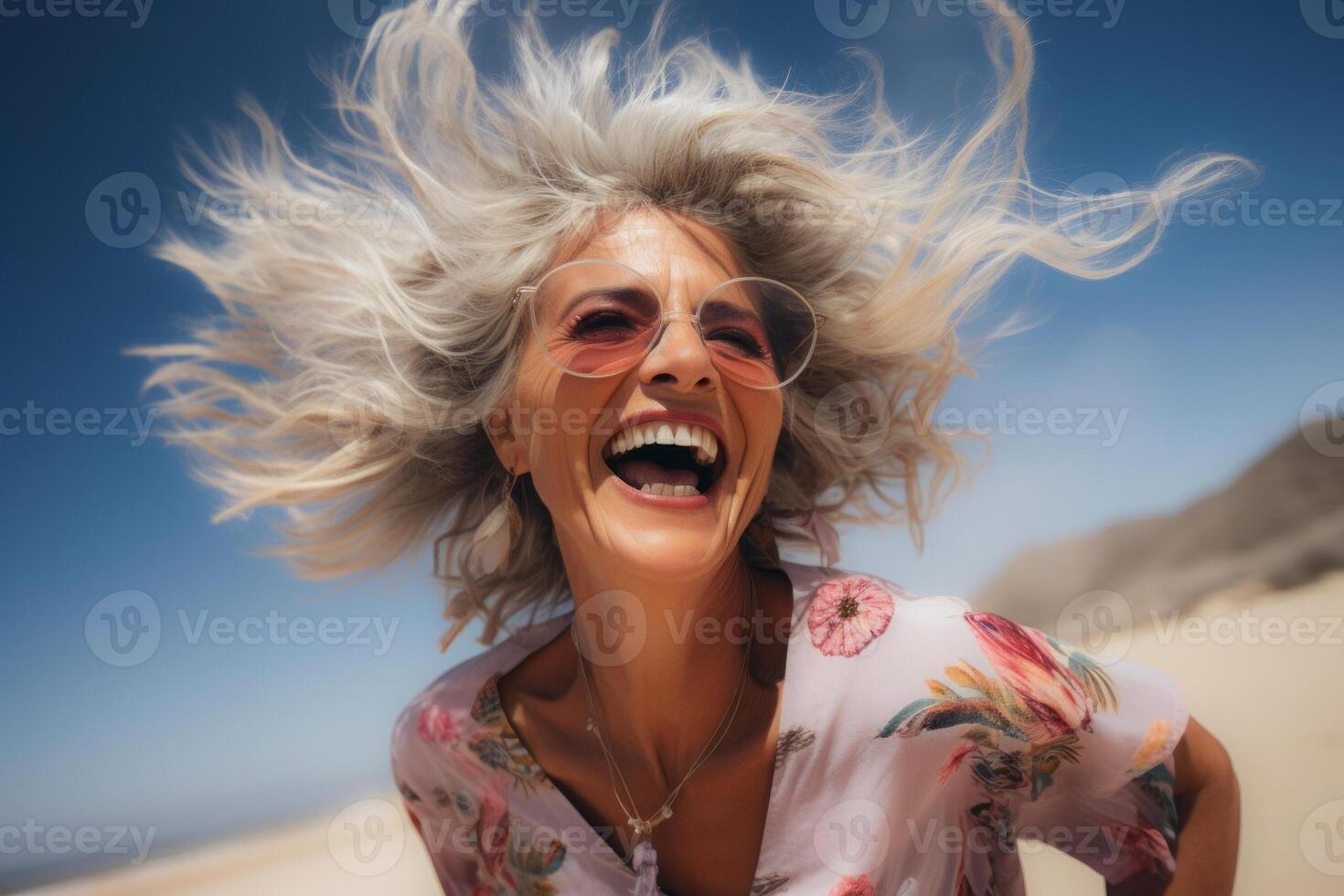 ai generado alegre mayor mujer riendo en soleado playa con viento en pelo foto