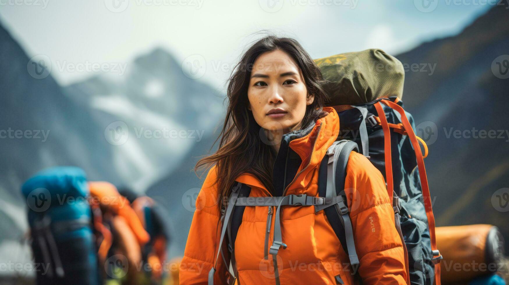 AI generated An Asian female adventurer in vibrant orange outerwear stands ready with a backpack, set against a dramatic mountain landscape, spirit of exploration. photo