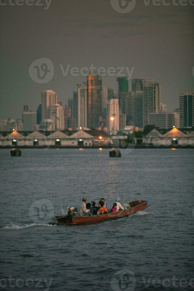 long tail boat in chaopraya river and bangkok skyscraper background photo