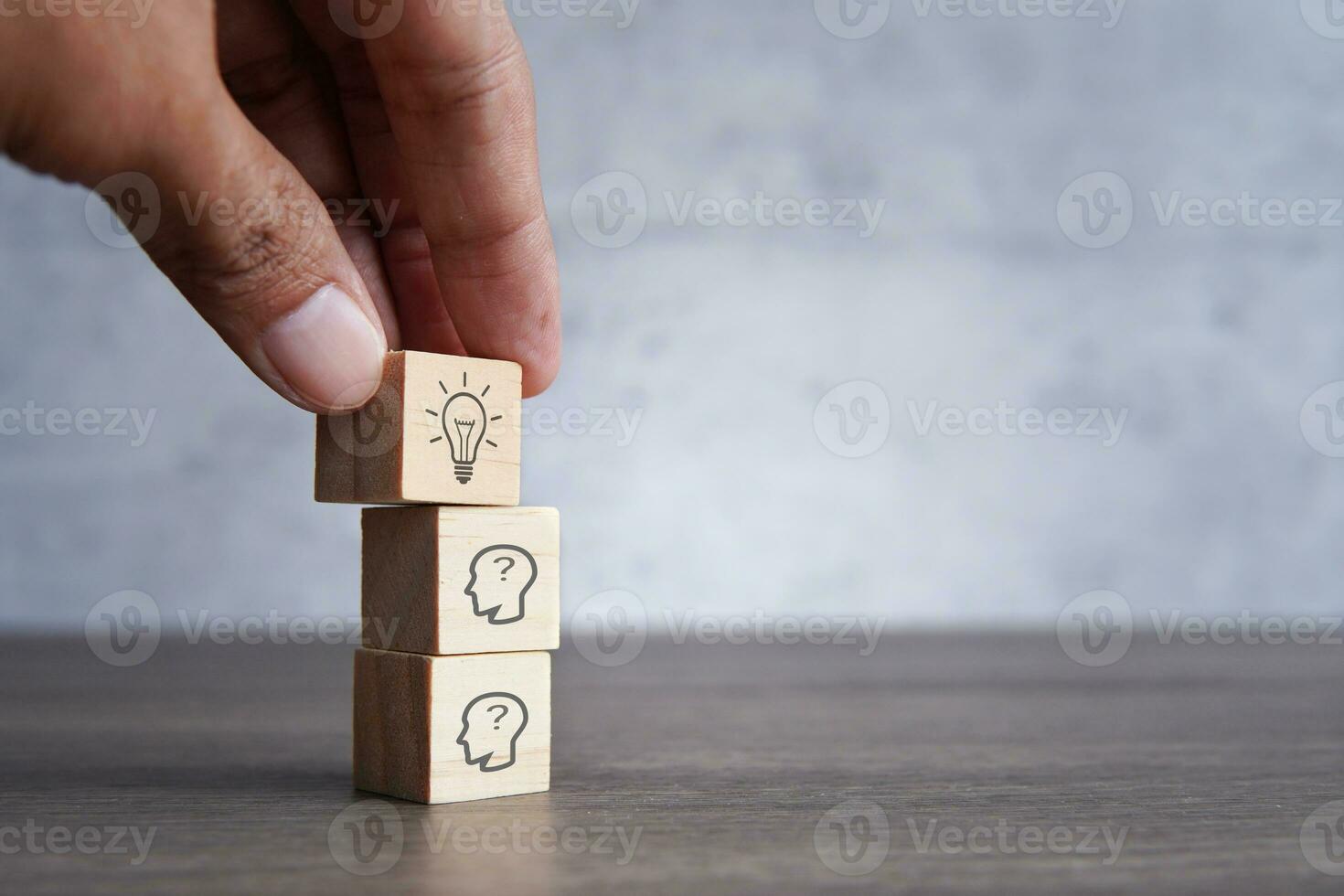 Hand pick wooden cubes with lightbulb icon on top of human head icon. Creative idea, brainstorming and innovation concept. photo