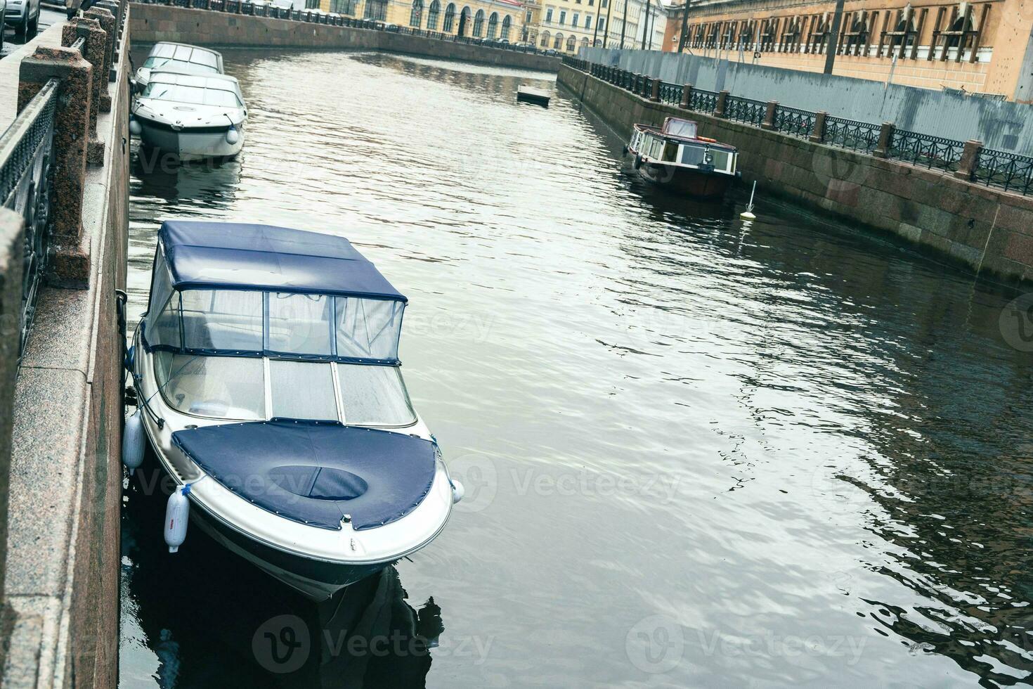 barcos y lanchas rápidas amarrado en un río ciudad canal con urbano paisaje en el antecedentes foto