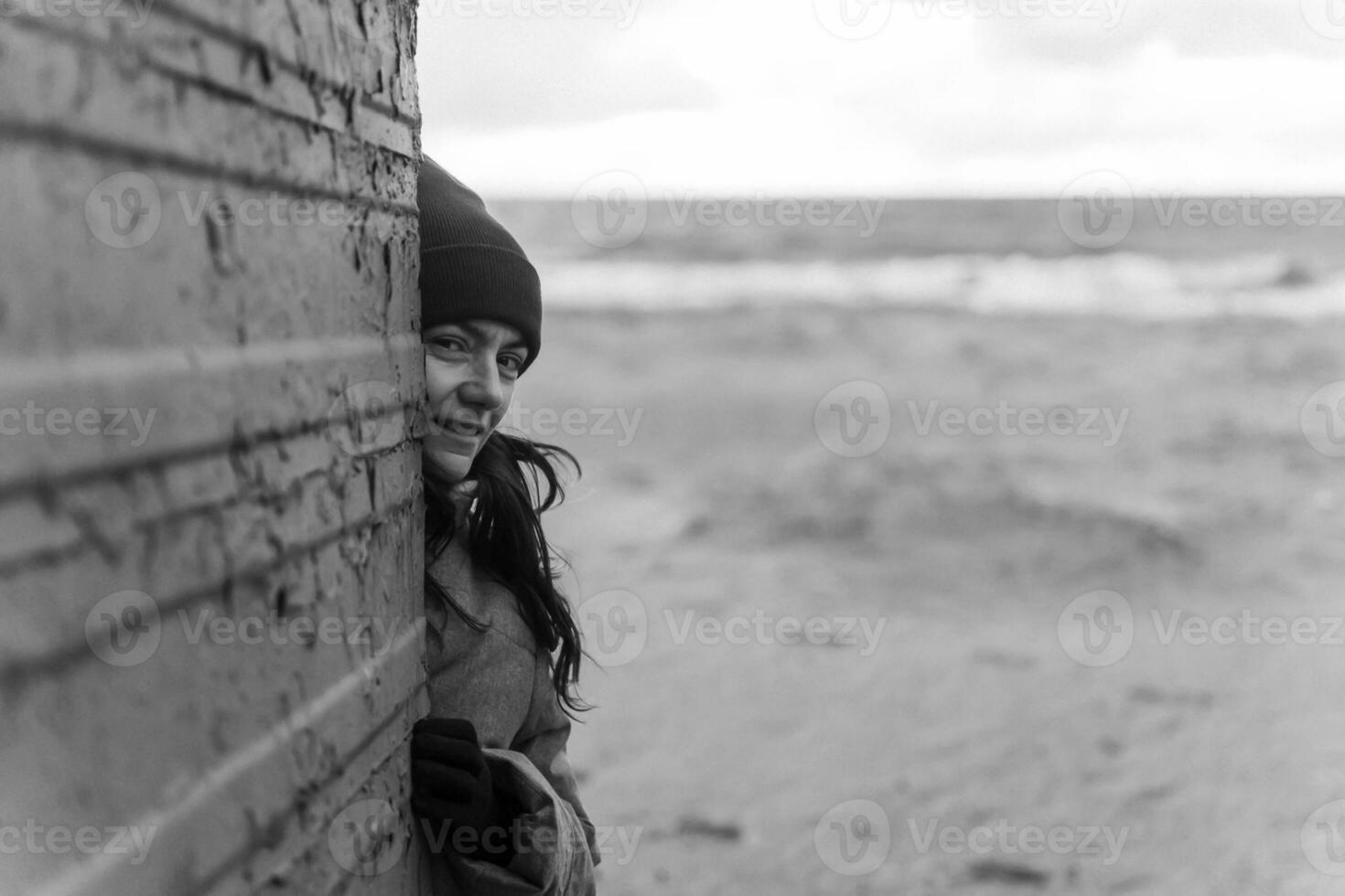 Autumn Beach Serenity. Woman Wearing Red Hat Poses by Old Changing Booth in Seaside Setting photo