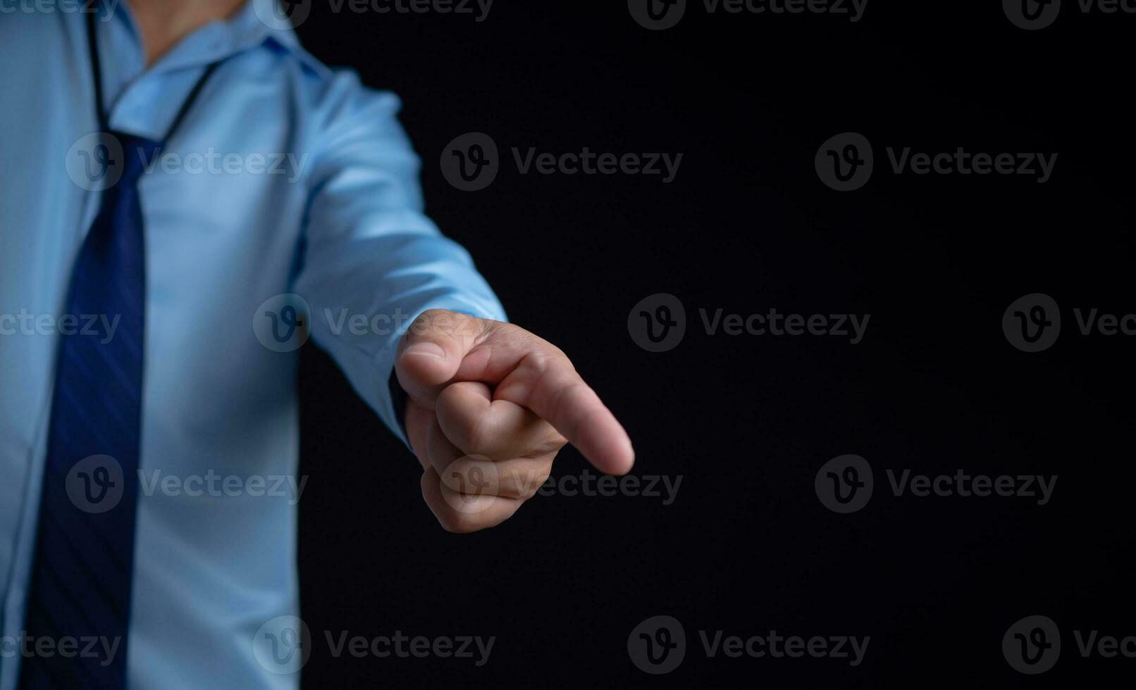 Employee makes a forward pointing gesture on a dark background. photo