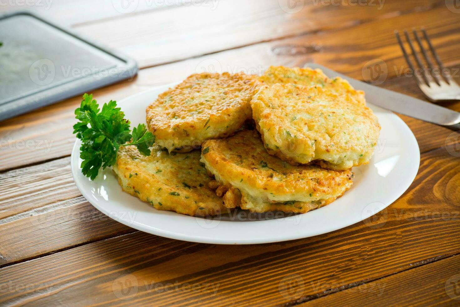 cooked fried potato cutlets with herbs photo