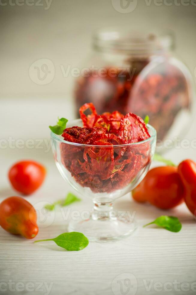 a handful of dried tomatoes and fresh tomatoes photo