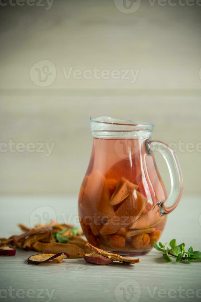 sweet cool compote boiled from various dried fruits, in a glass decanter photo